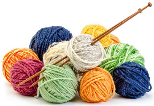 Bunte Wollknäule mit Stricknadeln